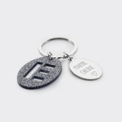 Porte-clés personnalisé médaille gravée ovale acier et breloque initiale acrylique pailleté bleu nuit